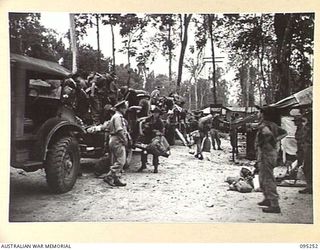 JACQUINOT BAY, NEW BRITAIN, 1945-08-11. HEADQUARTERS 11 DIVISION TROOPS WHO HAVE JUST ARRIVED EMBUSSING AT THE 5 DIVISION RECEPTION CAMP FOR THEIR VARIOUS UNITS. THE TROOPS ARE RELIEVING ..