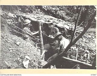 1943-08-09. NEW GUINEA. AN ADVANCED SIGNAL POST OUT IN A MOUNTAIN SIDE NEAR MUBO. LEFT TO RIGHT: CPL. CLEM. GUNNER, OF STAWELL, VIC., SIG. DON BECKWORTH, OF ASHFIELD, N.S.W. AND SIG. RON. MERRY, OF ..