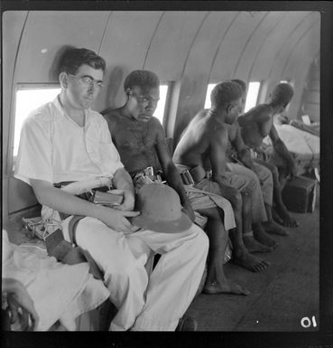 Reverend Keleher and local people on a Qantas Empire Airways' flight to Manus Island, Admiralty Islands, Bismarck Archipelago, Papua New Guinea
