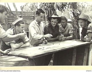 WARD'S DROME, PORT MORESBY, PAPUA, 1944-02. AUSTRALIAN AND AMERICAN SERVICEMEN PLAYING DICE DURING A LEISURE PERIOD AT WARD'S DROME