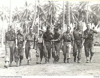 MILILAT, NEW GUINEA. 1944-08-22. MEMBERS OF THE "TASMANIACS", THE TASMANIAN LINES OF COMMUNICATION CONCERT PARTY, MAKING THEIR WAY TO THE THEATRE FOR A REHEARSAL. IDENTIFIED PERSONNEL ARE:- ..