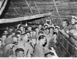 JACQUINOT BAY, NEW BRITAIN. 1945-02-03. TROOPS ENJOYING SOME COMMUNITY SINGING IN THE NEW YOUNG MEN'S CHRISTIAN ASSOCIATION AUSTRALIAN COMFORTS FUND SERVICES CLUB IN THE 5TH BASE SUB AREA AT THE ..