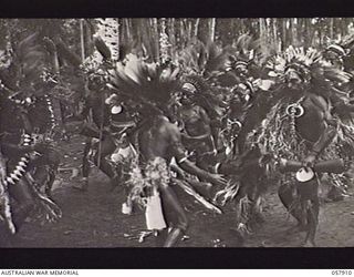 DOBODURA, NEW GUINEA. 1943-10-10. NATIVE CEREMONIAL DANCES IN PROGRESS IN THE VILLAGE CLEARING WERE ATTENDED BY ALLIED TROOPS AND NURSES