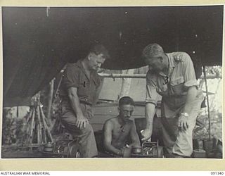 BOUGAINVILLE. 1945-04-27. MAJOR GENERAL C.H. SIMPSON, SIGNAL OFFICER IN CHIEF (3), INSPECTING CHOREHORSE CHARGERS AT 3 DIVISION SIGNALS (AIF), DURING HIS VISIT TO SOUTH BOUGAINVILLE TO INSPECT ..