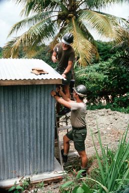 Builder 1ST Class Jeffrey A. Stevens and Steelworker 2nd Class Daniel O. Hurt repair toilet facilities at an elementary school on the island of Yap. The men, members of a United States (US) Navy construction battalion, are part of a Civic Action Team deployed to the area to aid villagers with construction projects and offer vocational training