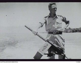 LAE, NEW GUINEA. 1943-09-30. OFFICER OF 2/6TH FIELD REGIMENT ON BOARD A LANDING CRAFT VEHICLE (LCV) WITH AN ANTI AIRCRAFT GUN AT THE REAR OF LCV, SOUTH OF THE MARKHAM RIVER