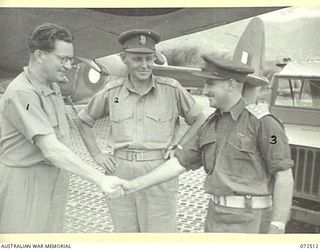 GOODENOUGH ISLAND, NEW GUINEA. 1944-04-22. THE HONOURABLE E.J. WARD, MINISTER FOR EXTERNAL TERRITORIES IN THE AUSTRALIAN GOVERNMENT (1), SHAKES HANDS WITH THE AUSTRALIAN NEW GUINEA ADMINISTRATIVE ..