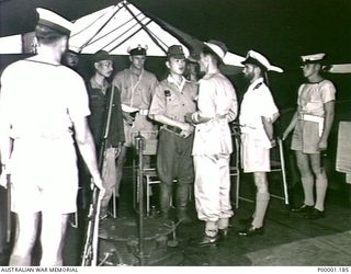 THE SOLOMON ISLANDS, 1945-08-20. JAPANESE SERVICE PERSONNEL ON BOARD HMAS LITHGOW OFF MOILA POINT LISTENING TO SURRENDER INSTRUCTIONS FROM AN AUSTRALIAN OFFICER. (RNZAF OFFICIAL PHOTOGRAPH.)