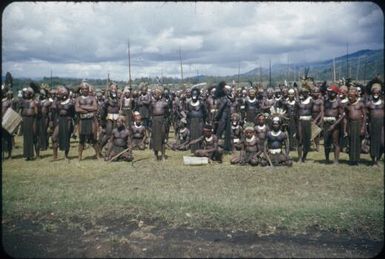 Tengerap Clan waiting for pay for work on the airstrip, some men are kneeling on the grass : Minj Station, Wahgi Valley, Papua New Guinea, 1954 / Terence and Margaret Spencer