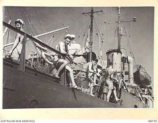 MIOS WUNDI, DUTCH NEW GUINEA. 1944-11-12. HMAS STAWELL CREW MEMBERS FISHING IN HARBOUR WHILE THEIR CORVETTE REFUELS FROM USS VICTORIA, USN