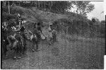 Pig festival, stake-planting, Tuguma: decorated men expel enemy spirits from dance ground with bespelled stakes and leaves