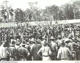 SONG RIVER, FINSCHHAFEN AREA, NEW GUINEA. 1944-03-26. AUSTRALIAN TROOPS VIEWING A NATIVE SING-SING IN THE AUSTRALIAN NEW GUINEA ADMINISTRATIVE UNIT COMPOUND CELEBRATING RE OCCUPATION OF THE AREA