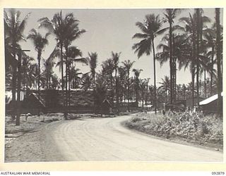 JACQUINOT BAY, NEW BRITAIN. 1945-06-09. BILLETS AND QUARTERS FOR ORDNANCE TROOPS IN THE HEADQUARTERS 5 BASE SUB-AREA. THEY ARE SITUATED ON THE LEFT OF THE ROAD WITH ORDNANCE STORES ON THE RIGHT AND ..