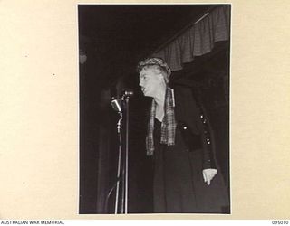 LAE AREA, NEW GUINEA. 1945-08-18. GRACIE FIELDS PRESENTING A NUMBER DURING HER CONCERT AT THE LAE BASE THEATRE