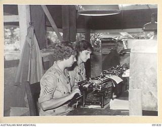 LAE, NEW GUINEA, 1945-05-15. SERGEANT B.G. RANDLE (1), AND PRIVATE M. REID (2), WORKING AT THEIR NEW JOB WITH ENGINEERS, HQ FIRST ARMY. A FEW DAYS AFTER THEIR ARRIVAL FROM AUSTRALIA AWAS PERSONNEL ..
