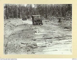 BOUGAINVILLE ISLAND. 1945-02-14. AUSTRALIAN ARMY JEEPS MOVING ALONG A CORDUROY SECTION OF THE JABA SOUTH ROAD BUILT BY THE TROOPS OF THE 61ST INFANTRY BATTALION