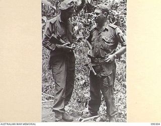 BOUGAINVILLE. 1945-03-31. LT L.E. FORSYTH, TP COMD, B SQUADRON, 2/4 ARMOURED REGIMENT (HOLDING A WALKIE-TALKIE IN HIS HAND) (1), IN DISCUSSION WITH MAJ K.M.H. ARNOTT, OFFICER COMMANDING B SQUADRON ..