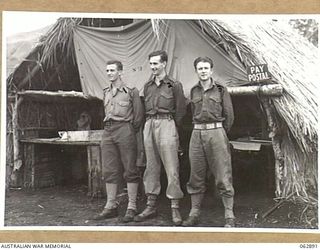 RAMU VALLEY, NEW GUINEA. 1944-01-15. PERSONNEL OF THE PAY AND POSTAL SECTION OF THE 58/59TH INFANTRY BATTALION, 15TH INFANTRY BRIGADE OUTSIDE THEIR OFFICE. THEY ARE: VX113028 SERGEANT M. E. EMMETT ..