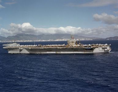 An elevated port beam view of the nuclear-powered aircraft carrier USS CARL VINSON (CVN 70) approaching Pearl Harbor. Members of the crew are manning the rail