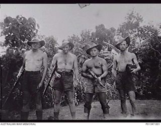 NEW GUINEA? 1944? HOLDING HIS CAMERA, A PHOTOGRAPHER FROM THE MILITARY HISTORY SECTION WITH AN ARMED ESCORT. LEFT TO RIGHT: UNKNOWN; TX11674 SIGNALMAN H. FLASKAS, 24TH LINE SECTION, 18TH LINES OF ..