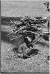 Child carries large bundle of firewood and garden produce on head