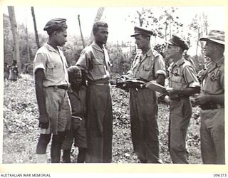 MALAGUNA MISSION, NEW BRITAIN, 1945-09-10. REPRESENTATIVES OF THE RED CROSS SOCIETY, ATTACHED 4 INFANTRY BRIGADE, INTERVIEWING HALF-CASTE CIVILIANS. TROOPS OF 4 INFANTRY BRIGADE OCCUPIED THE AREA ..