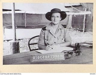 BOUGAINVILLE, 1945-06-18. NURSING SISTER CAPTAIN ELIZABETH IRENE UREN, WORKING IN HER OFFICE AT 109 CASUALTY CLEARING STATION, MOTUPENA POINT