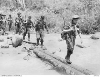 FARIA VALLEY, NEW GUINEA. 1944-02-10. MEMBERS OF "A" COMPANY, 2/10TH INFANTRY BATTALION, CROSSING THE FARIA RIVER AT IRIE ON THEIR JOURNEY TO RAMU VALLEY AFTER BEING RELIEVED BY THE 58/59TH ..