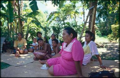 Group sitting on mats under trees