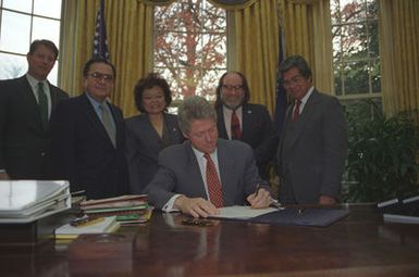 Photograph of President William Jefferson Clinton Signing Public Law 103-150 in the Oval Office at the White House in Washington, D.C.