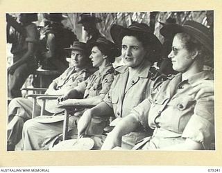 MANGUNUI, JACQUINOT BAY, NEW BRITAIN. 1945-02-25. MEMBERS OF THE AUSTRALIAN ARMY NURSING SERVICE FROM THE 105TH CASUALTY CLEARING STATION WATCHING WITH INTEREST THE NATIVE DANCERS AND SINGERS AT A ..