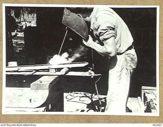 RAMU VALLEY, NEW GUINEA. 1943-12-21. VX118331 SAPPER G. R. WEYMES OF THE 53RD AUSTRALIAN FIELD PARK COMPANY, ROYAL AUSTRALIAN ENGINEERS, 7TH AUSTRALIAN DIVISION, ARC WELDING A STEEL POST