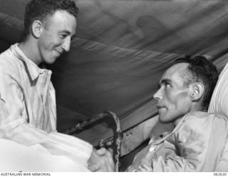 PORT MORESBY, PAPUA, NEW GUINEA. 1943-12-30. NX97542 PRIVATE R. COPPIN (LEFT) CONGRATULATING QX20656 PRIVATE R. KELLIHER VC, A COMRADE OF THE 2/25TH AUSTRALIAN INFANTRY BATTALION, 7TH AUSTRALIAN ..