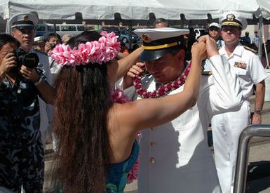 Chinese Peoples Liberation Army Navy Rear Adm. Wang Fushan, Deputy Commander, North Sea Fleet, receives a lei from a Polynesian dancer before departing Naval Station Pearl Harbor, Hawaii, on Sept. 10, 2006. Chinese Sailors from two ships, the Luhu (Type 052) Class Guided Missile Destroyer QINGDAO (DDG 113) and the Fuquing Class Replenishment Ship HONGZEHU (AOR 881), spent three days at NS Pearl Harbor during a Goodwill Visit. (U.S. Navy photo by Mass Communication SPECIALIST 1ST Class James E. Foehl) (Released))
