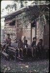 Young children and older boy on veranda of Hutchins' house