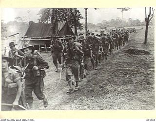 1943-10-02. NEW GUINEA. MARKHAM VALLEY. OLD MUNUM. AUSTRALIAN TROOPS MARCH FORWARD FROM OLD MUNUM. (NEGATIVE BY MILITARY HISTORY NEGATIVES)