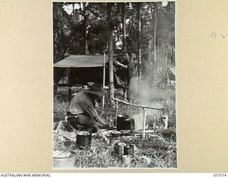 REMPI, NEW GUINEA. 1944-05-09. BX120716 PRIVATE L. MATTISSON (1), AND NX192250 PRIVATE J. GRAF (2), COOKS FROM D COMPANY, 35TH INFANTRY BATTALION, COOKING THEIR EVENING MEAL NEAR REMPI AND ..