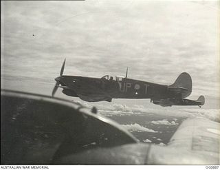 BISMARCK ARCHIPELAGO. 1944-03-28. AIRCRAFT, CODE NAMED UP-T, OF NO. 79 (SPITFIRE) SQUADRON RAAF, IN FLIGHT OVER NEW BRITAIN ENROUTE FROM KIRIWINA TO THE ADMIRALTY ISLANDS. PHOTO TAKEN FROM A ..
