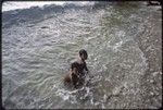 Children play in surf, on the east coast of Kiriwina