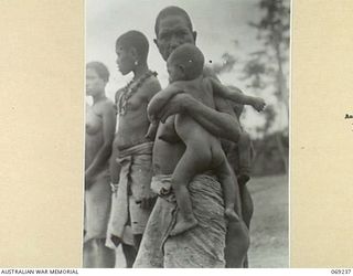 MENDAROPU, NEW GUINEA. 1942-10. NATIVE WOMEN FROM THE OUTLYING VILLAGES STANDING AROUND DURING THE SALE OF THEIR FRUIT AND VEGETABLES TO TROOPS OF THE 128TH REGIMENT, 32ND UNITED STATES DIVISION