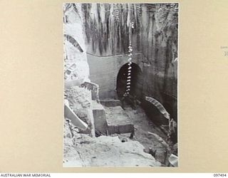 TUNNEL HILL ROAD, RABAUL, NEW BRITAIN. 1945-10-03. LOOKING DOWN AT THE ENTRANCE TO AN UNDERGROUND TUNNEL. THE JAPANESE MADE EXTENSIVE USE OF TUNNEL SYSTEMS IN THE RABAUL AREA AFTER ABOVEGROUND ..