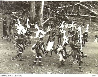 KAMALGAMAN ANCHORAGE, JACQUINOT BAY, NEW BRITAIN. 1944-12-31. NEW GUINEA NATIVES DANCING AND SINGING DURING A SING-SING IN THE AUSTRALIAN NEW GUINEA ADMINISTRATIVE UNIT NATIVE COMPOUND