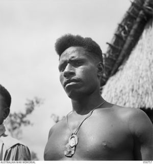 BISIATABU, NEW GUINEA. 1943-10-26. 323 CORPORAL EHAVA MM, 1ST PAPUAN INFANTRY BATTALION, RECEIVED HIS DECORATION UNDER THE FOLLOWING CIRCUMSTANCES. "ON 1943-02-21, NEAR NINIANDA, ON THE OPI RIVER, ..