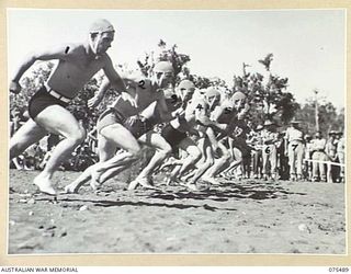 LAE, NEW GUINEA. 1944-08-27. COMPETITORS BREAKING THE LINE AT THE START OF THE TEAMS RACE DURING THE SURF CARNIVAL ORGANISED BY HQ, 5TH DIVISION AT MALAHANG BEACH. IDENTIFIED PERSONNEL ARE:- MAJOR ..