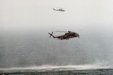 A right side view of a Helicopter Mine Countermeasures Squadron 14 (HM-14) RH-53D Sea Stallion helicopter towing a lightweight magnetic sweep during mine contermeasures operations. The helicopter is assigned to the amphibious assault ship USS GUAM (LPH 9). Note: Fifth view in a series of six