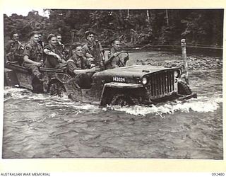 BOUGAINVILLE. 1945-05-20. MEDIUM MACHINE-GUNNERS OF 24 INFANTRY BATTALION CROSSING THE HONGORAI RIVER AT MACKLIN'S CROSSING. THE JEEP AND TRAILER IS LOADED WITH GUNS AND EQUIPMENT DURING THE ..