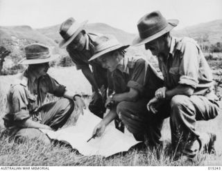 1943-07-09. NEW GUINEA. WAU-MUBO AREA. OFFICERS STUDY A MAP IN A FORWARD AREA ALONG THE MUBO TRACK. CAPT. R. ISHERWOOD, OF SURREY HILLS, VIC., LT. W.M. IRVING OF HAWTHORN, VIC., CAPT. R. FLEMMING, ..