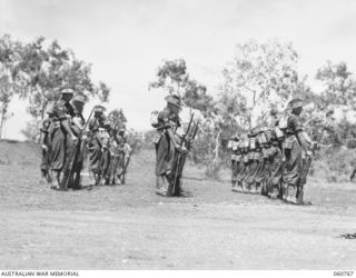 POM POM VALLEY, NEW GUINEA. 1943-11-27. GUARD OF THE 2/10TH AUSTRALIAN INFANTRY BATTALION, THE CHAMPIONS OF THE 18TH AUSTRALIAN INFANTRY BRIGADE FIXING BAYONETS DURING THE TAKING OF A TRAINING FILM ..