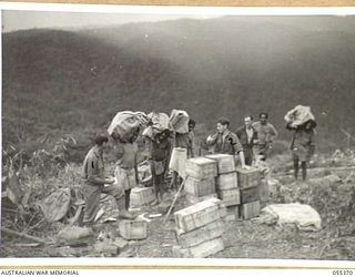 GOODVIEW, NEW GUINEA, 1943-08-05. CHECKING SUPPLIES AT THE GOODVIEW DROPPING GROUND ARE VX2104 CORPORAL T. A. CROSBIE (EXTREME LEFT), AUSTRALIAN ARMY SERVICE CORPS, 6TH AUSTRALIAN DIVISION, AND ..