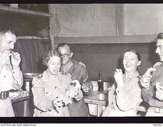 RABAUL, NEW BRITAIN, 1945-12-27. MATRON E. M. WHITE, PRINCIPAL MATRON, FIRST ARMY, WHO IS VISITING RABAUL, ENJOYING A CHICKEN BONE WITH MATRON E. M. GREEN, 118TH AUSTRALIAN GENERAL HOSPITAL, IN THE ..